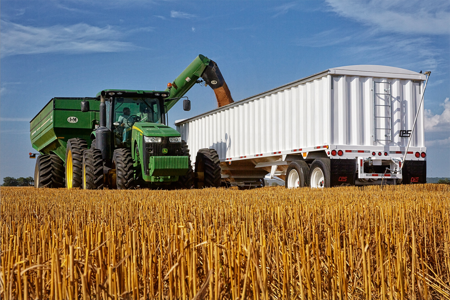 Wheat harvest in Missouri, with John Deere tractors and MANAC trailers