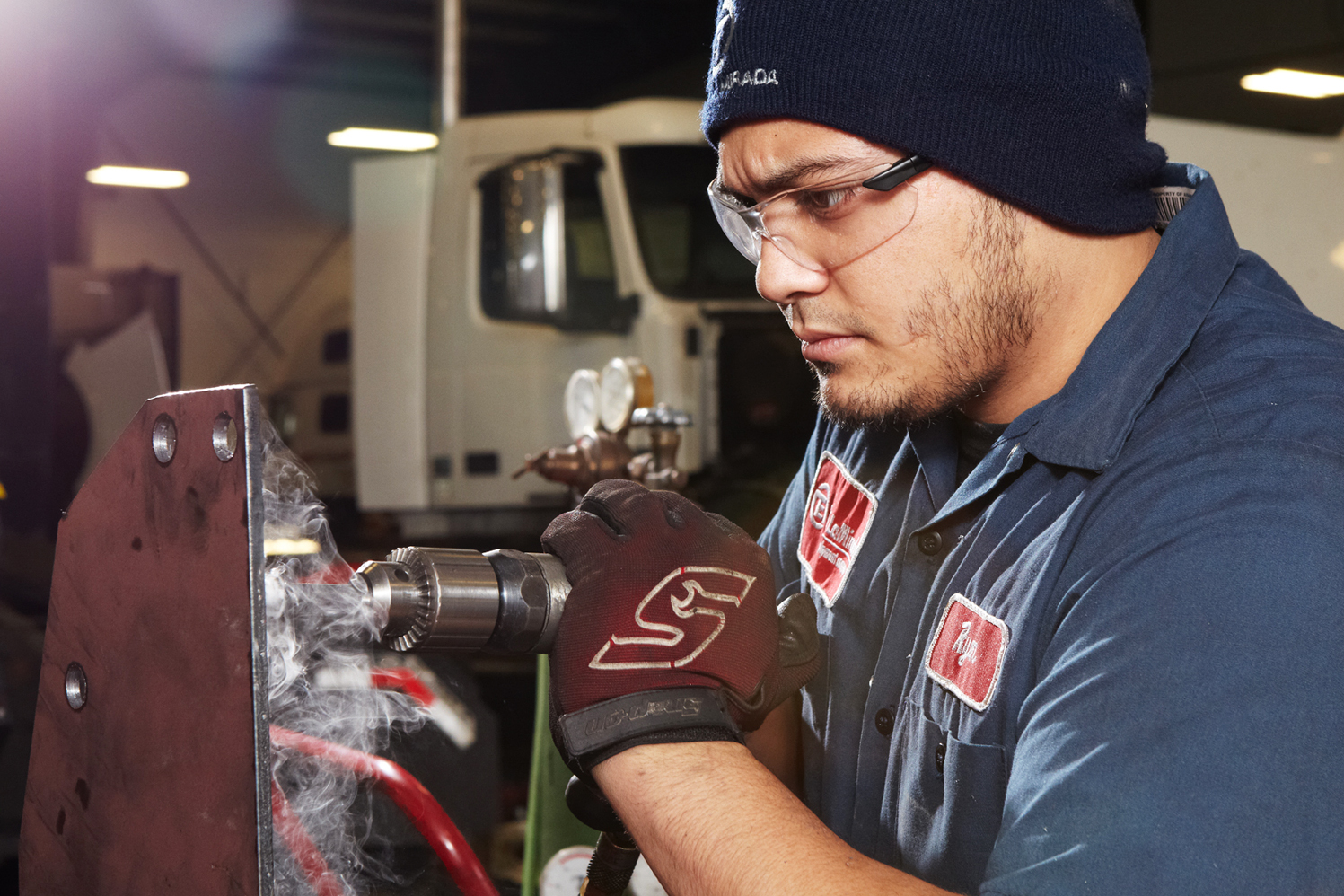 A technician in Southern California punches a hole in a metal plate.