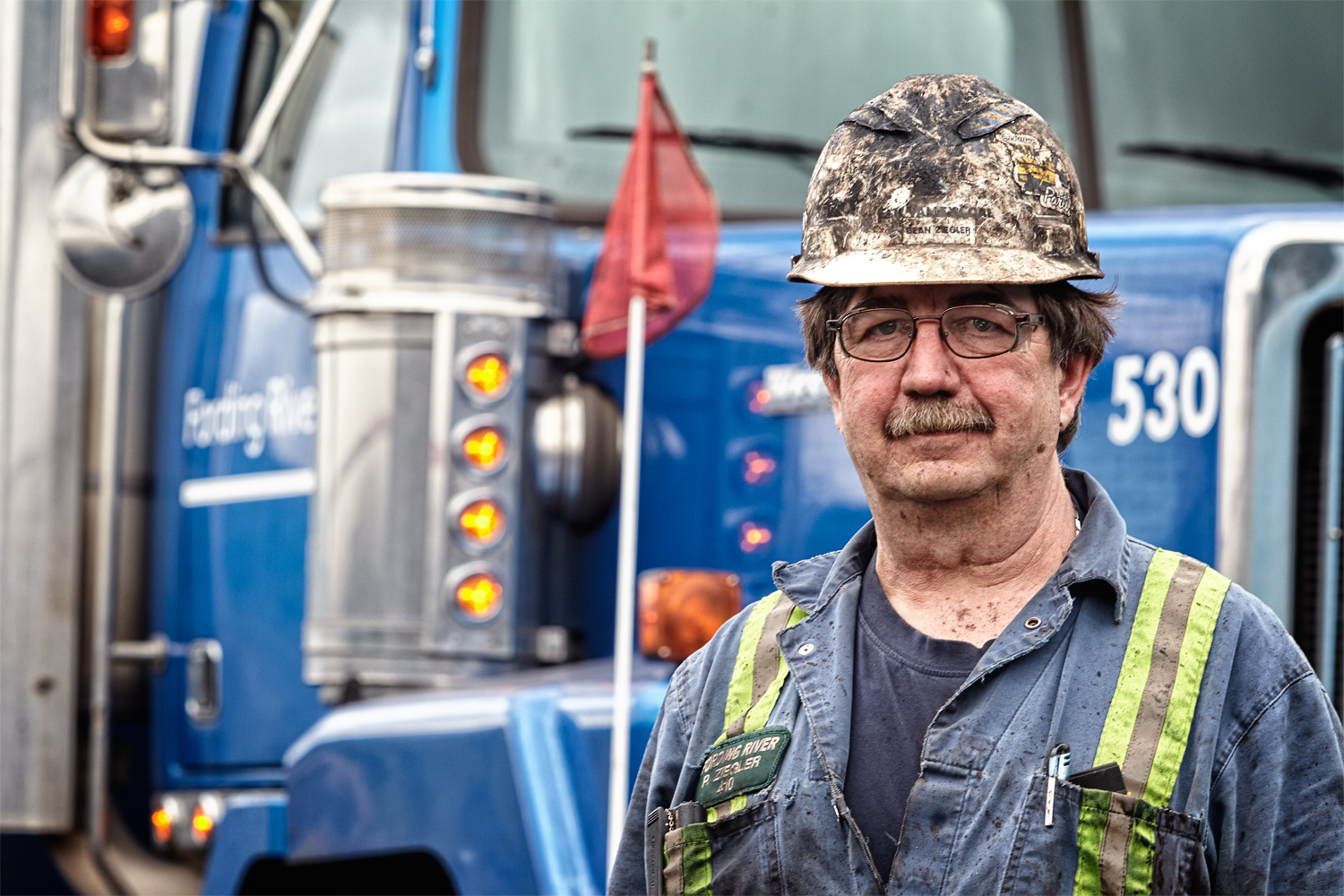 A mountain-top mine worker poses with his truck in British Columbia.