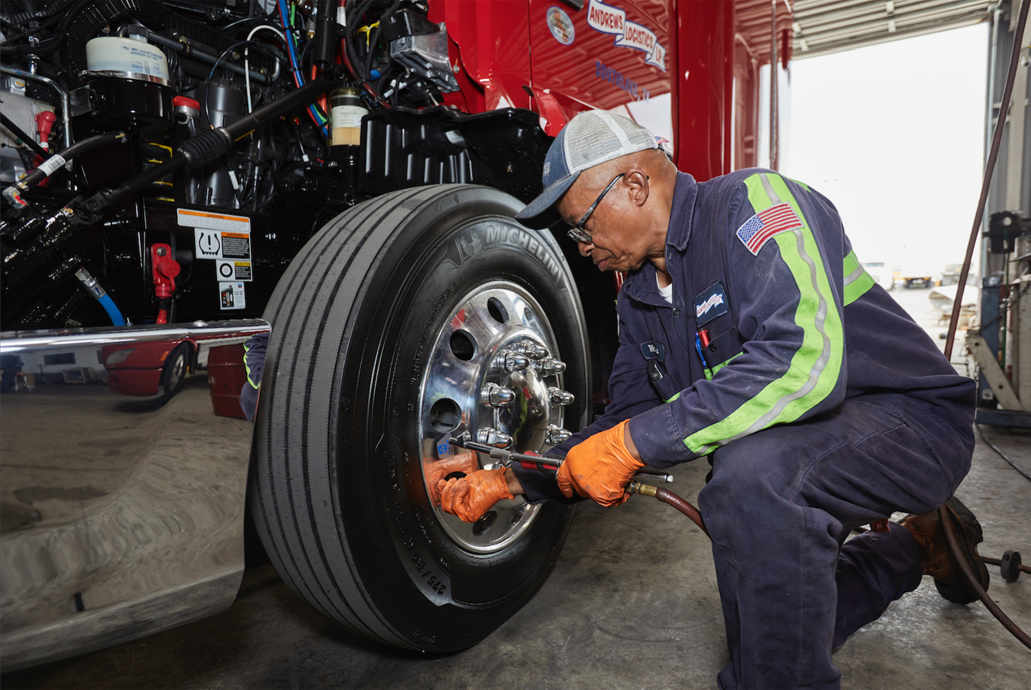 A technician checks tire air pressure, prepping a new truck for the road.