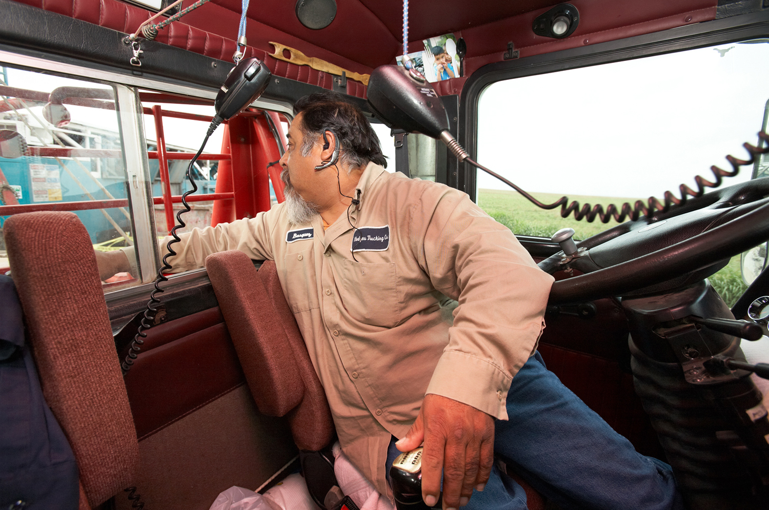 Working the back window: An oilfield driver in Texas watches as he works the rear winch on his truck.