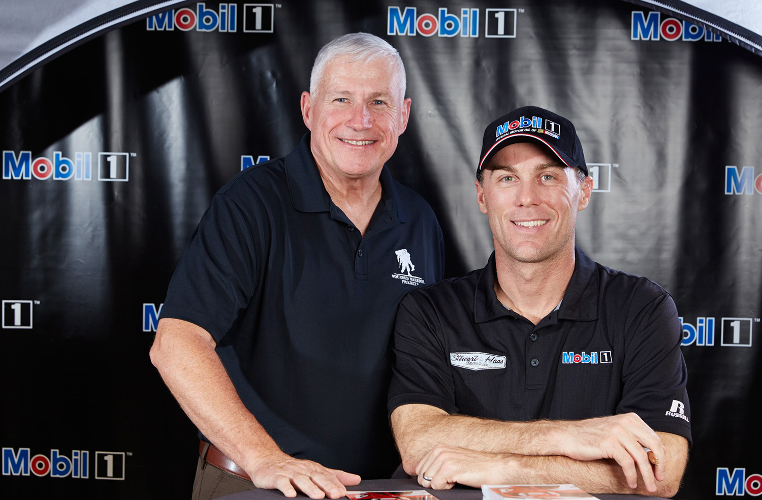 A racing fan leans in to take a photograph with NASCAR driver Kevin Harvick.