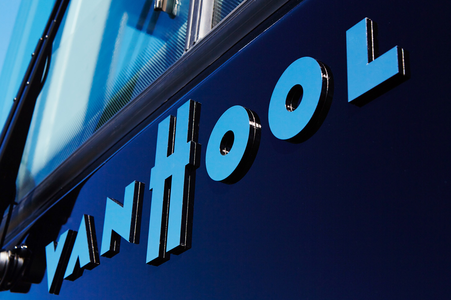 Up close with the Van Hool branding on the front of a motor coach.