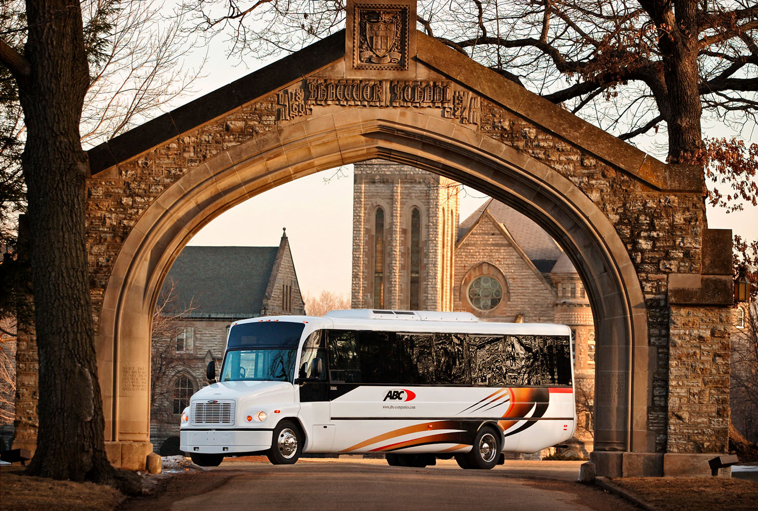 A transit coach is framed by the elegant archway of a private high school in southern Minnesota.