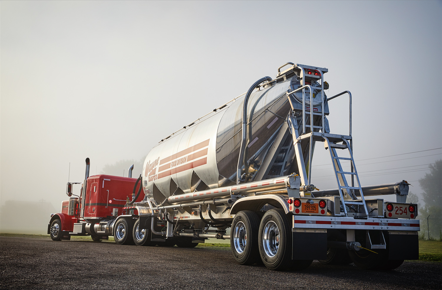 An LBT pneumatic trailer and Peterbilt Model 389 tractor glow in morning light